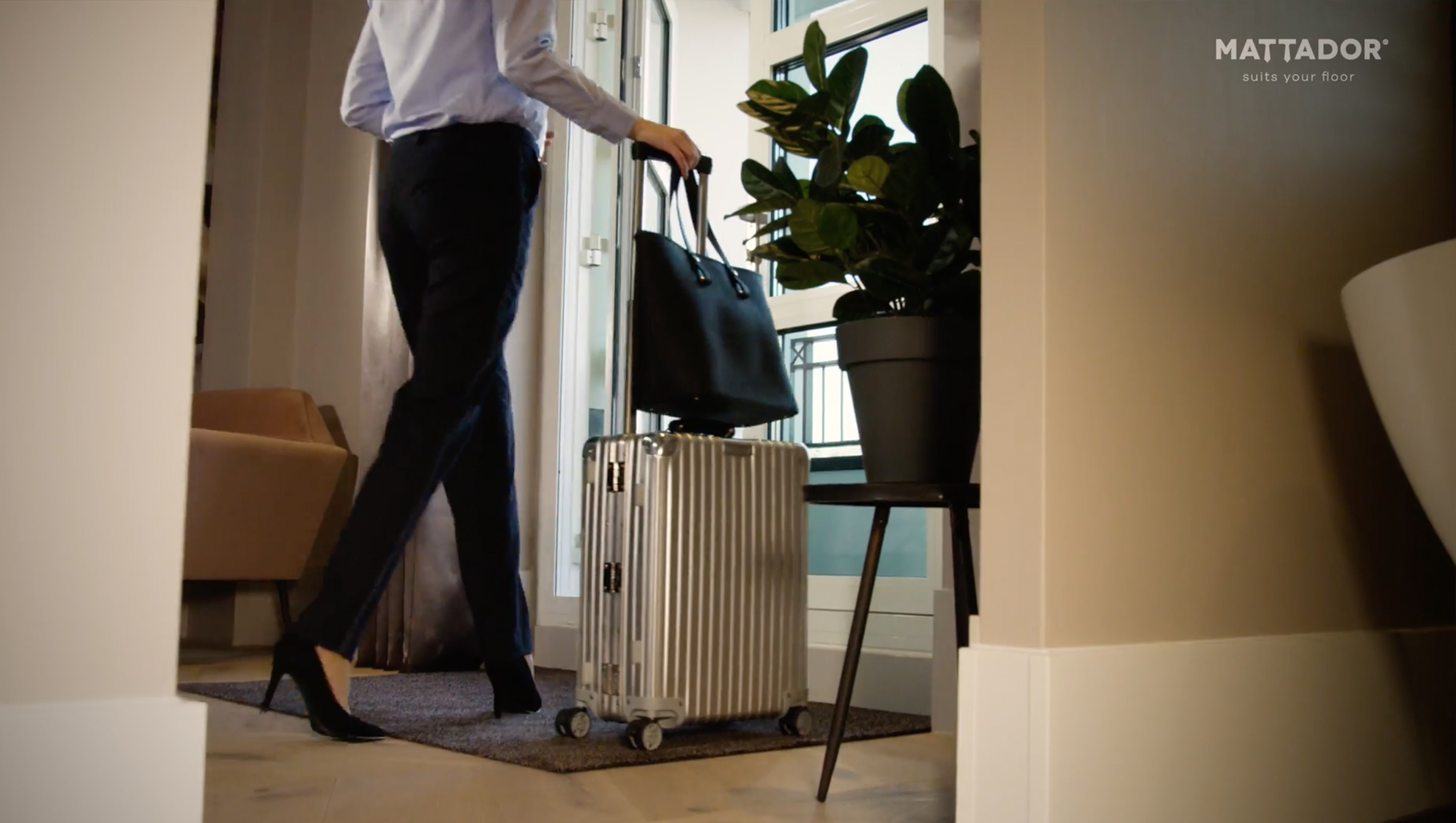 Bruine binnenmat in hotel met vrouw met koffer